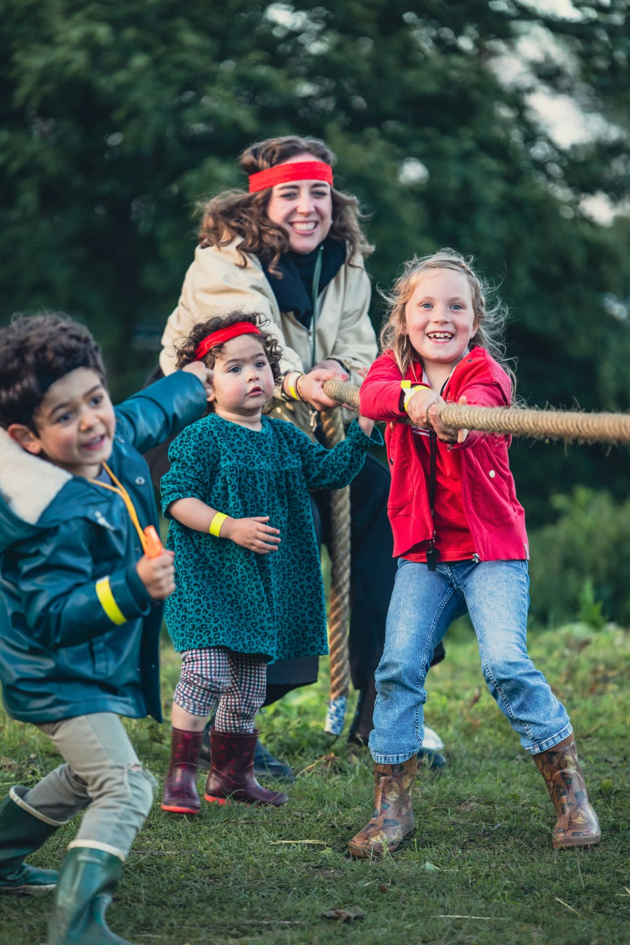 Kids and a neighbor playing tug-of-war outdoors